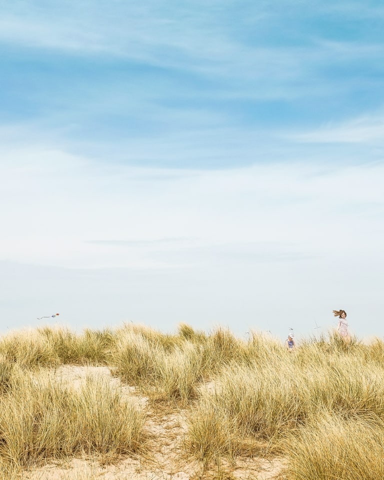 Girl playing in long Beach Grass.